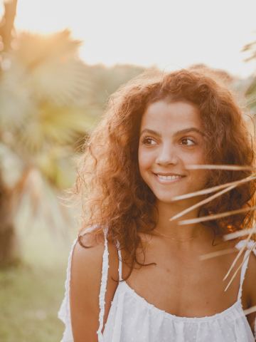 Jeune femme aux cheveux bouclés qui sourit