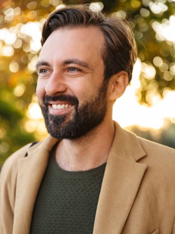 Homme barbu souriant en veste camel